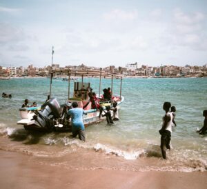Costa de África occidental con barcos de pesca tradicionales y un atardecer de colores intensos