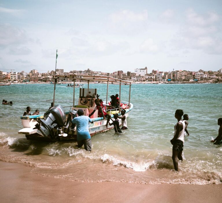 Costa de África occidental con barcos de pesca tradicionales y un atardecer de colores intensos