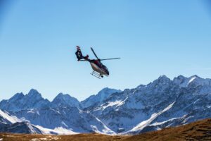helicóptero sobrevolando montañas alpinas en heli-hiking