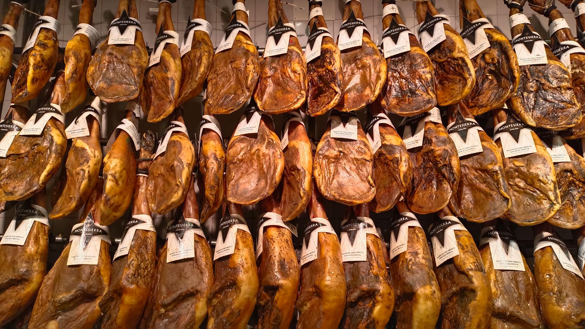 Museo del Jamón en Madrid: guía para visitarlo en 2026 1 Patas de jamón ibérico colgadas en mercado español