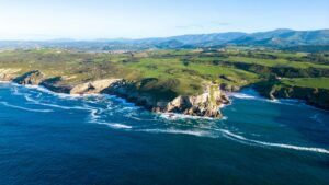 Costa de Asturias con colinas verdes y océano azul desde el aire