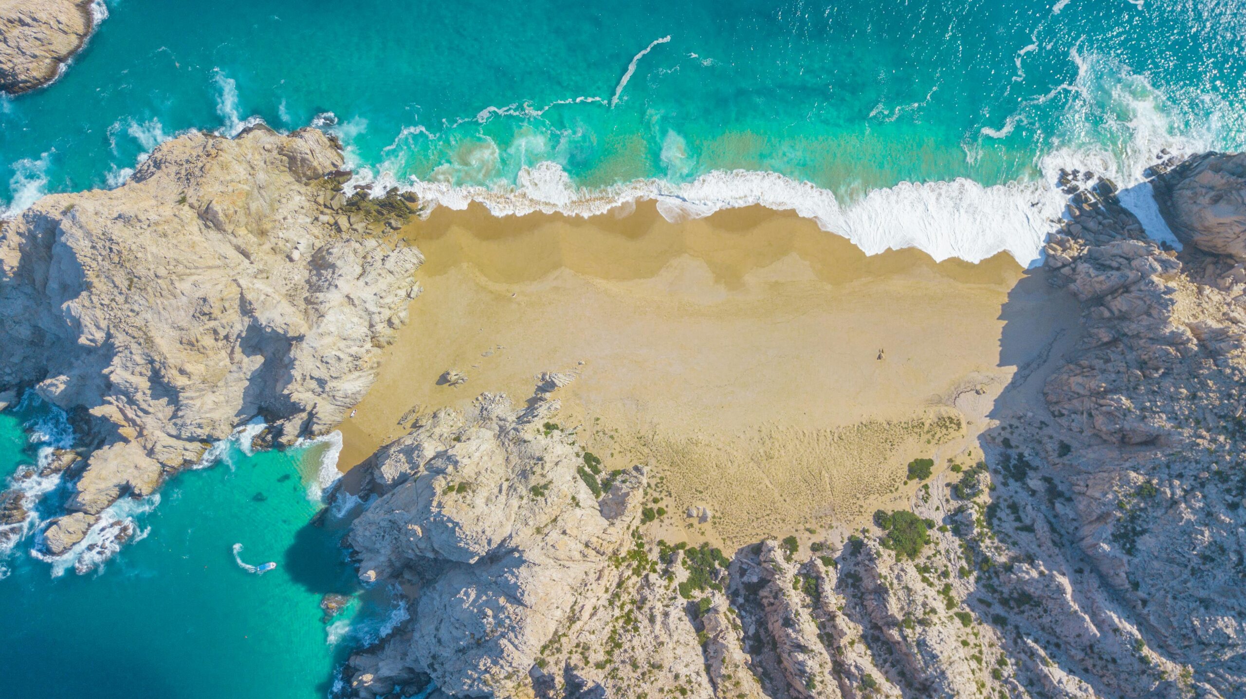 Vista aérea de Divorce Beach en Cabo San Lucas con aguas turquesas y arena dorada