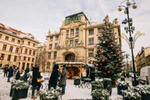árbol de navidad iluminado en plaza europea con mercado navideño