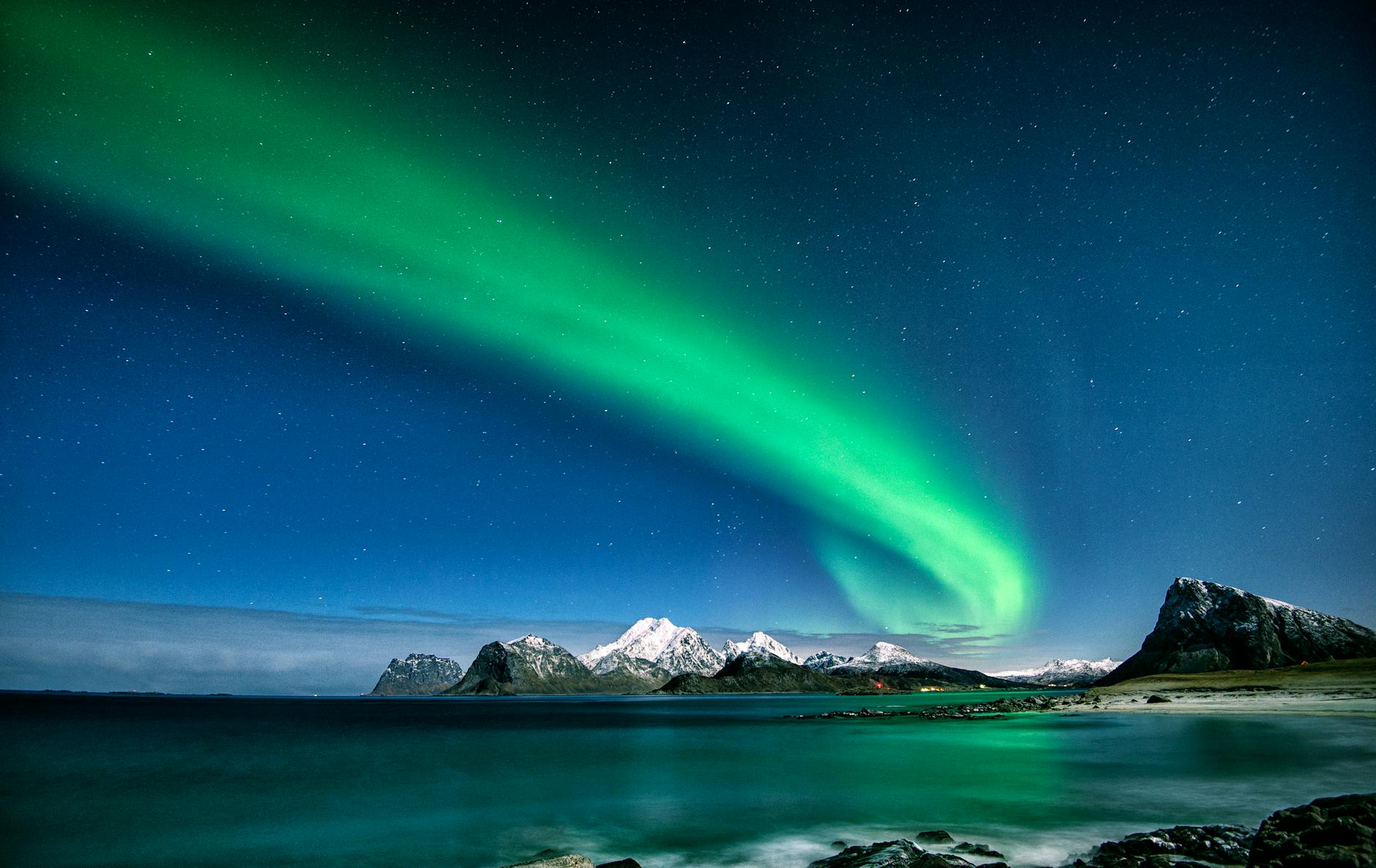 Crucero navideño por los fiordos noruegos con Hurtigruten 2 Aurora boreal iluminando el cielo nocturno sobre los fiordos de Noruega