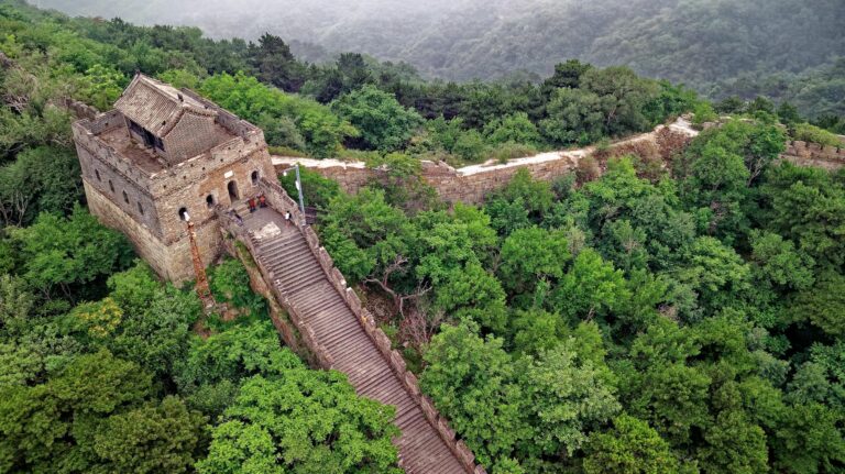 Gran Muralla China en montañas verdes bajo cielo azul
