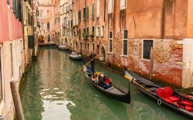 Góndola navegando por los canales de Venecia al atardecer
