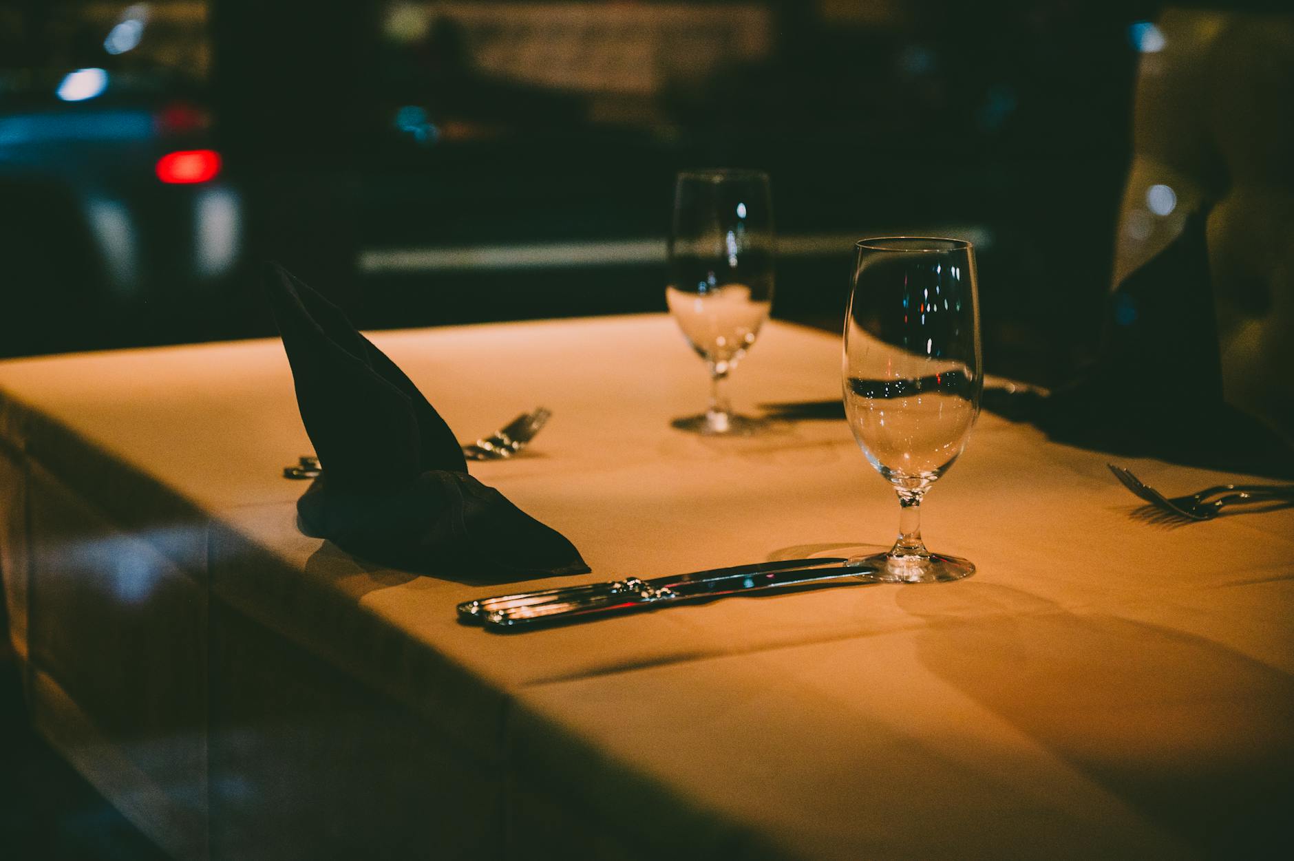 Cena de lujo en Disney World: Victoria & Albert's 2026 2 Mesa de restaurante de lujo con cubiertos y copas de vino bajo luz cálida