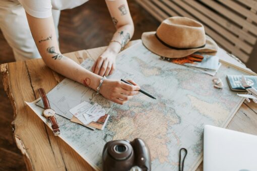 Home Elementor 1 Mujer planificando un viaje con mapa del mundo, pasaportes y ordenador
