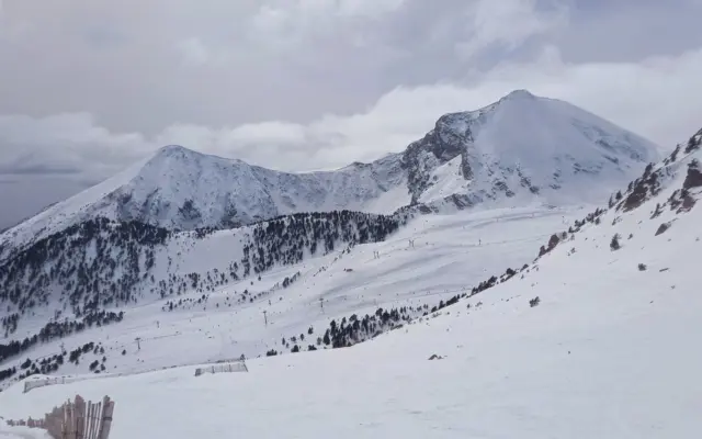 Pistas de esquí en los Pirineos españoles con nieve fresca y cielo azul