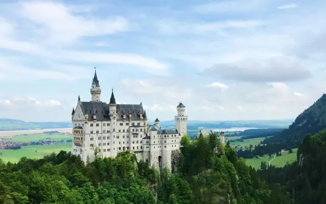 Castillo de Neuschwanstein en Baviera rodeado de bosques alpinos y niebla