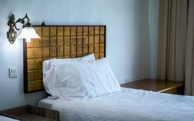 Cama de hotel bien hecha con almohadas blancas y sábanas limpias para dormir cómodo viajando