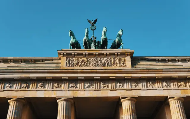 Calle animada de Berlín con terrazas y edificios históricos al atardecer