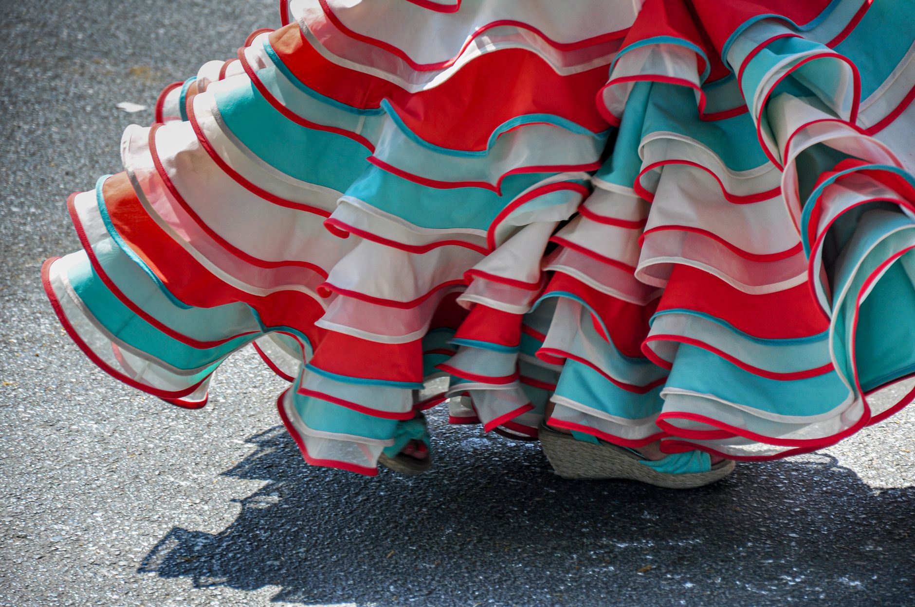 Falda de flamenco en rojo, turquesa y blanco capturando el movimiento del baile