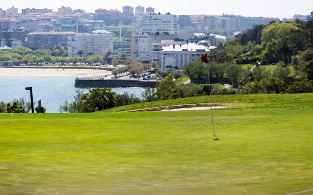 Campo de golf con vistas a una ciudad costera soleada