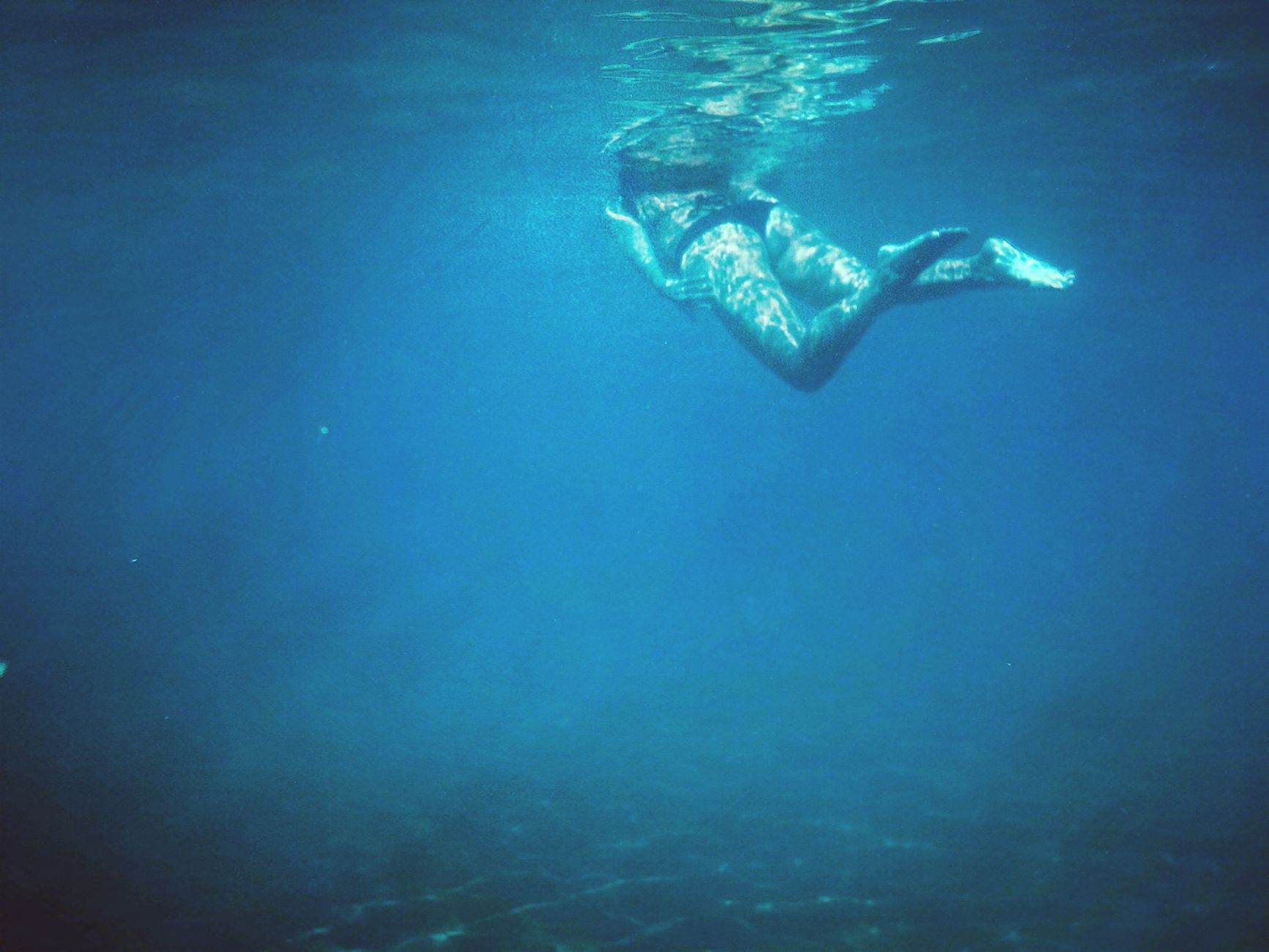 Bucear en Creta: guía de inmersiones en la isla griega 1 Barco de buceo anclado en cala de aguas turquesas de Creta