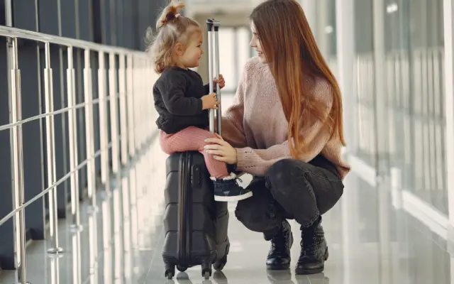 Familia con maletas en aeropuerto viajando con niños