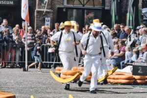 Mercado de queso holandés con ruedas de queso y portadores