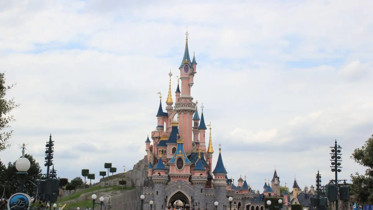 Castillo de Disneyland iluminado con fuegos artificiales por la noche