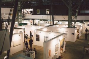 Sala de exposición de arte contemporáneo con visitantes observando obras