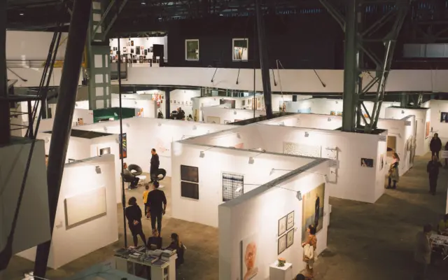 Sala de exposición de arte contemporáneo con visitantes observando obras