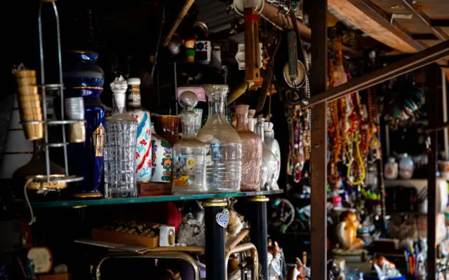 Vitrina con cristalería y objetos vintage en una tienda de antigüedades