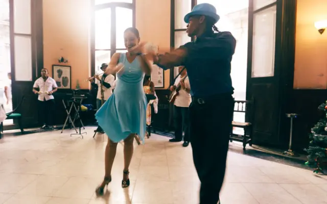 Pareja bailando swing en un salón con música en directo
