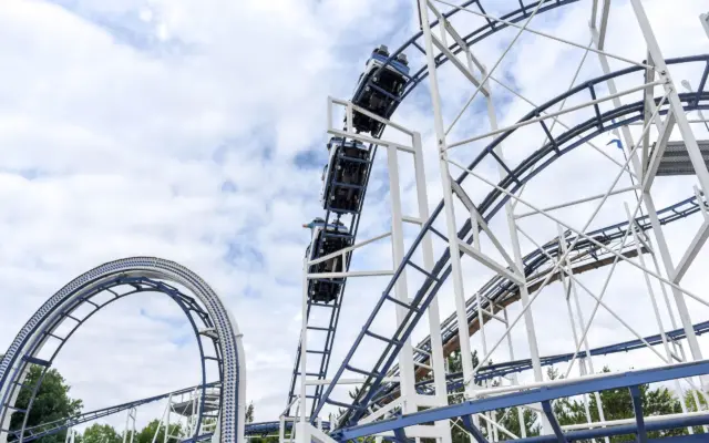 Montaña rusa de acero bajo un cielo azul en un parque de atracciones