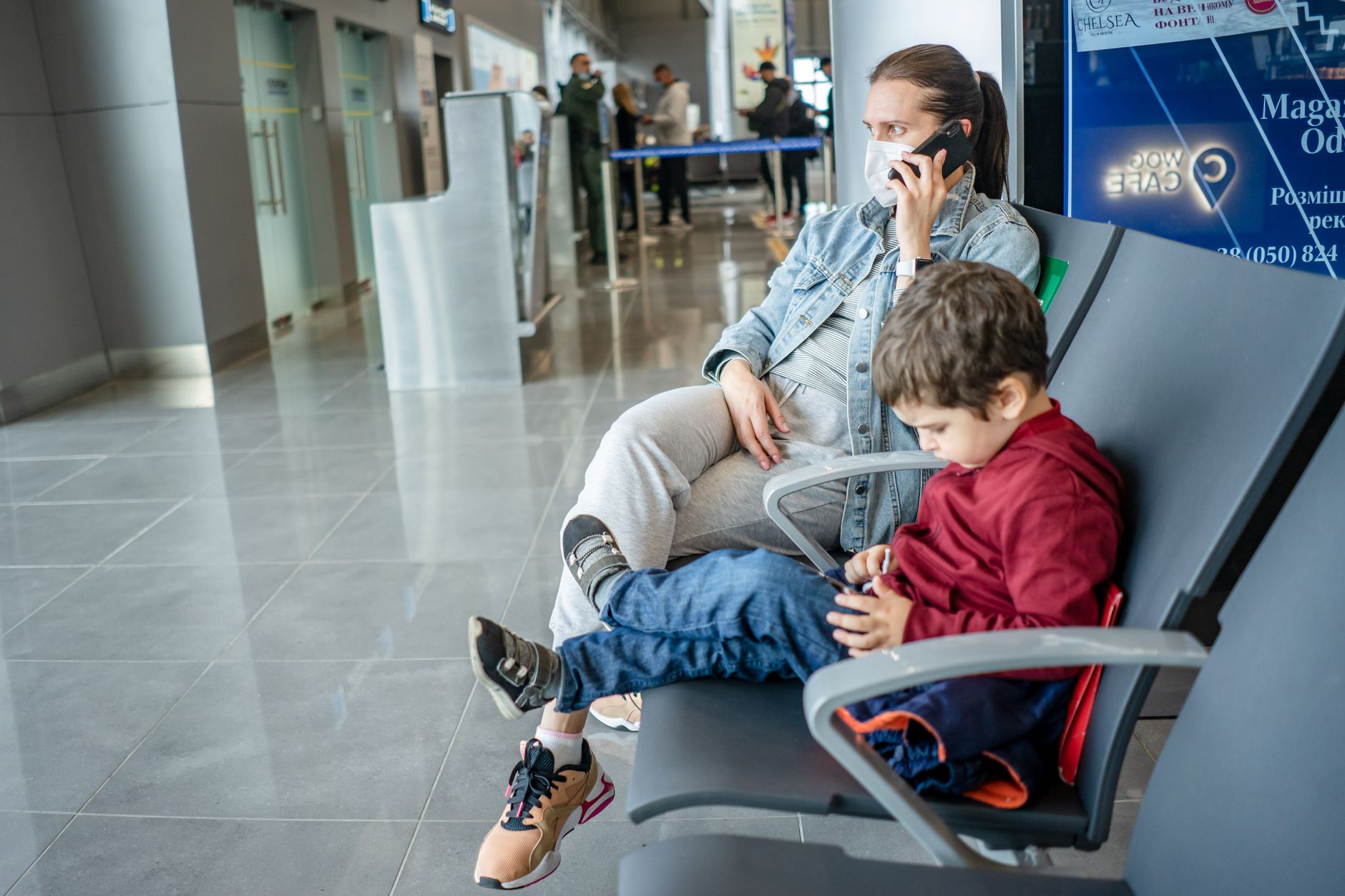 Madre e hijo en la terminal del aeropuerto esperando su vuelo