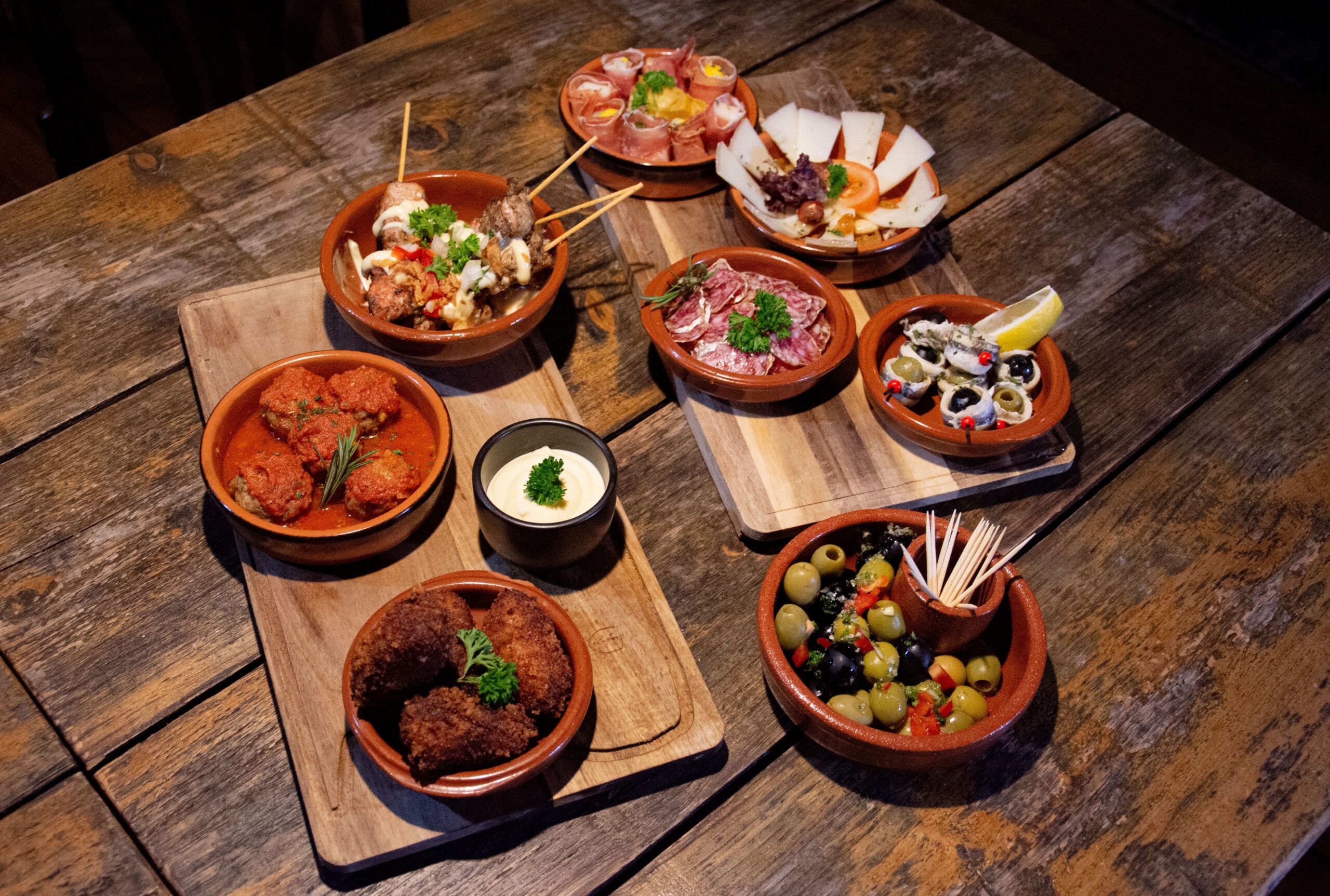 Sevilla en Semana Santa con lluvia: plan B sin procesión 2 Tapas tradicionales españolas servidas en tablas de madera