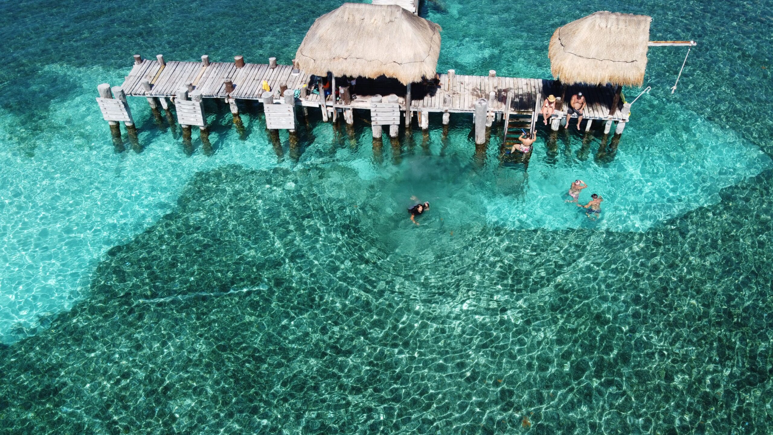 Muelle de Isla Mujeres con turistas y aguas cristalinas