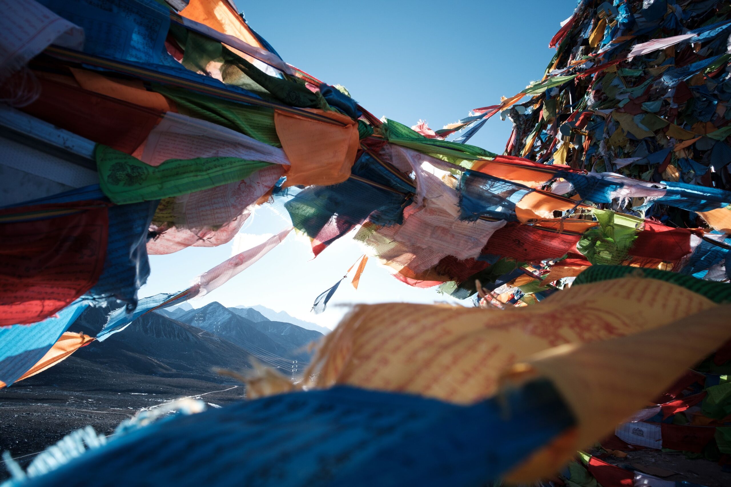 Banderas de oración tibetanas ondeando con las montañas del Himalaya al fondo