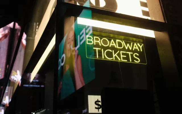 Cartel de neón de Broadway con entradas para espectáculos en Nueva York de noche