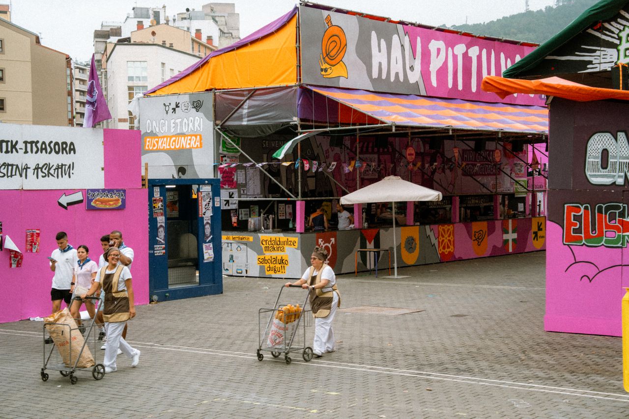 Ambiente festivo en una feria popular con puestos de colores y gente en la calle