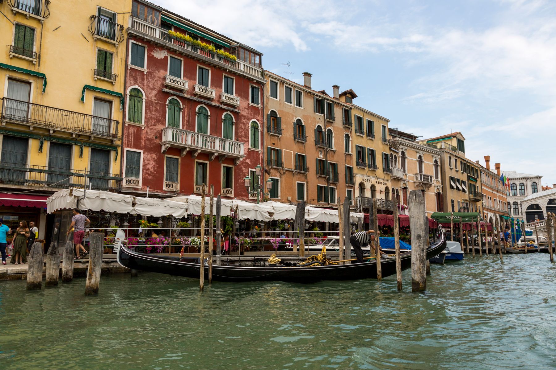 Góndolas alineadas junto a fachadas de colores en un canal de Venecia