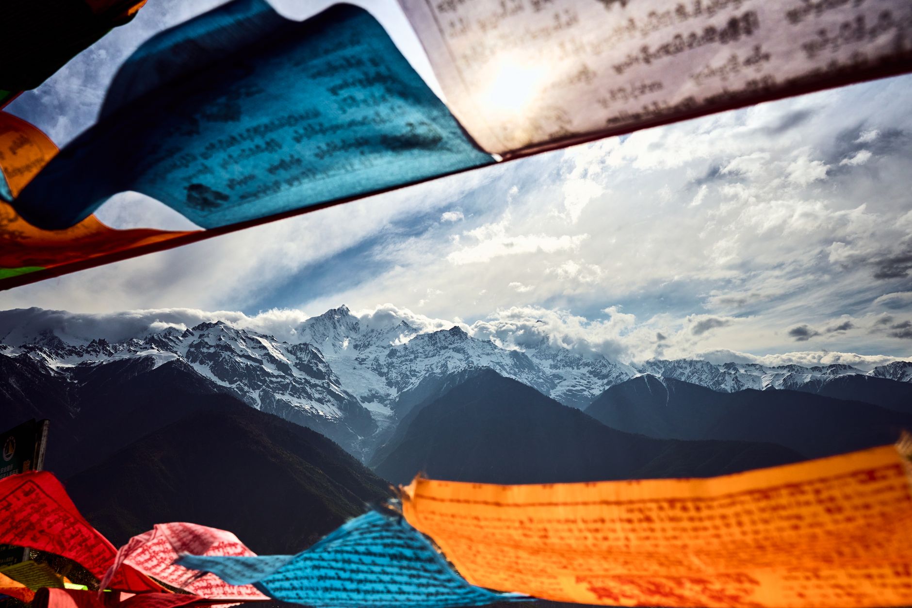 Por qué el Tíbet cierra a los turistas extranjeros cada marzo 2 Banderas de oración tibetanas con montañas del Himalaya al fondo