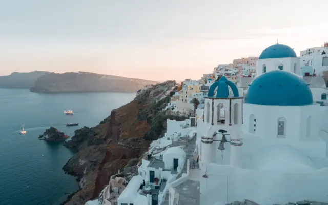 Cúpulas azules de Santorini al atardecer sobre el mar Egeo