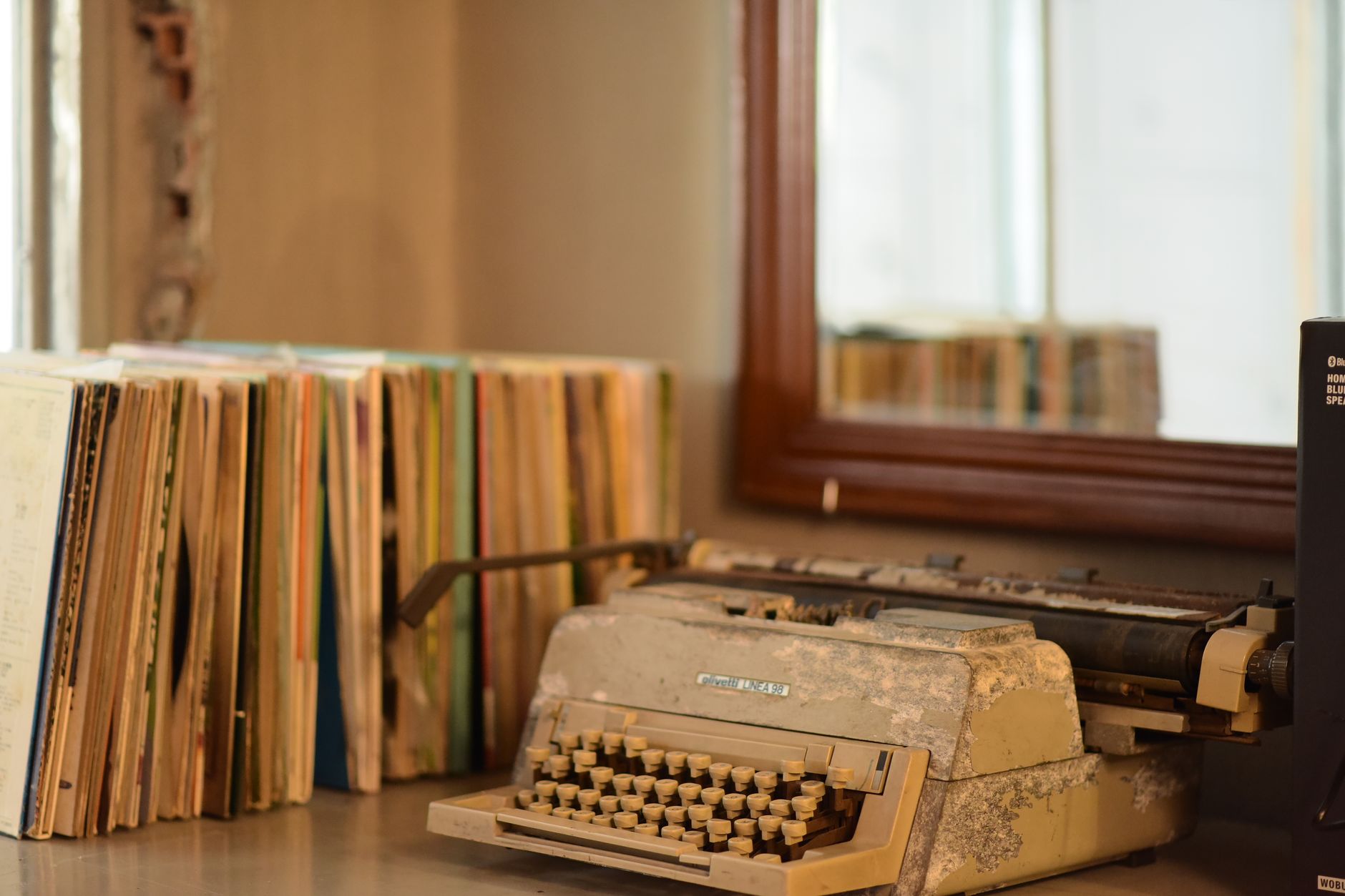 Máquina de escribir antigua junto a libros viejos