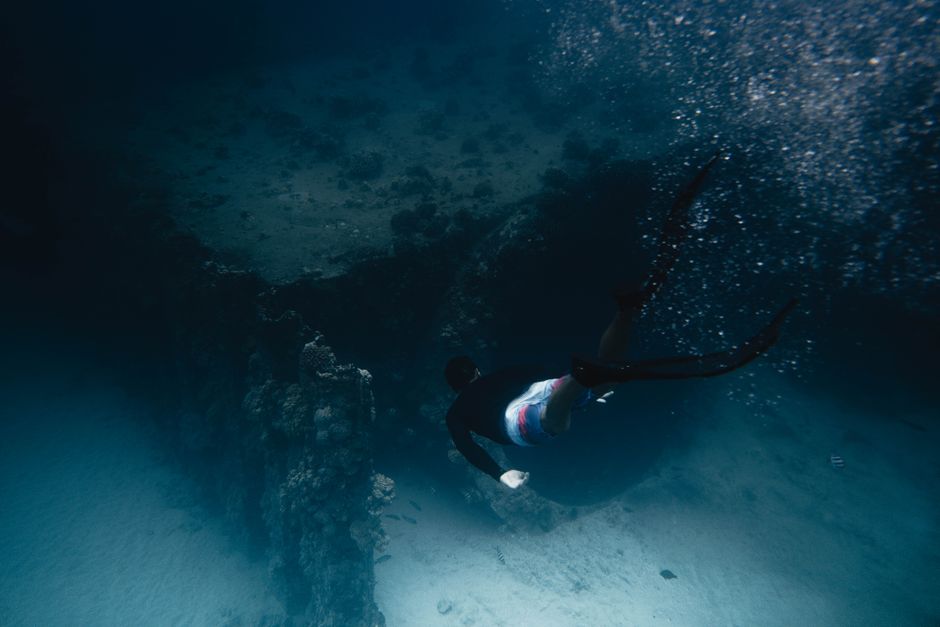 Yonaguni: bucear en el misterioso monumento sumergido de Japón 2 Buceador nadando junto a formaciones rocosas submarinas