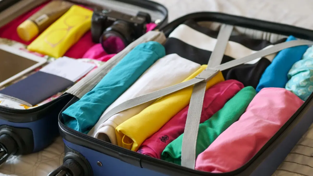 Accesorios de viaje ordenados sobre una maleta abierta