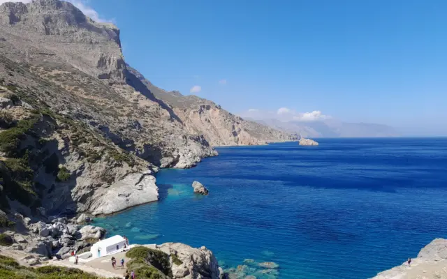 Capilla blanca sobre un acantilado junto al mar en una isla griega