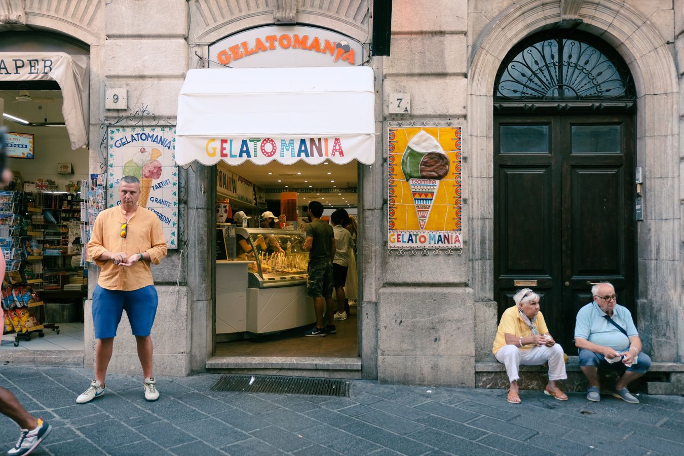 Entrada de una heladeria italiana con vitrina de gelato artesanal y clientes en la puerta