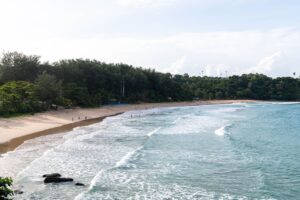 Playa de Phuket, Tailandia, con vegetación exuberante y oleaje suave