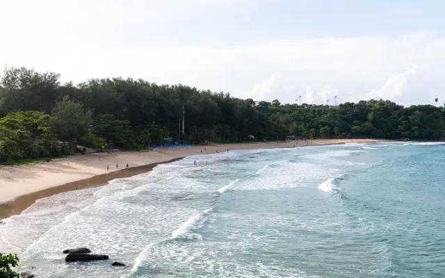 Playa de Phuket, Tailandia, con vegetación exuberante y oleaje suave