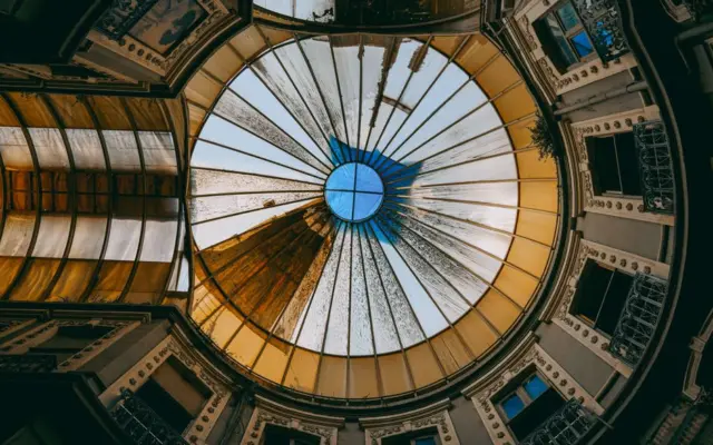 Cupula interior con vidrieras geometricas en tonos suaves, estilo art deco