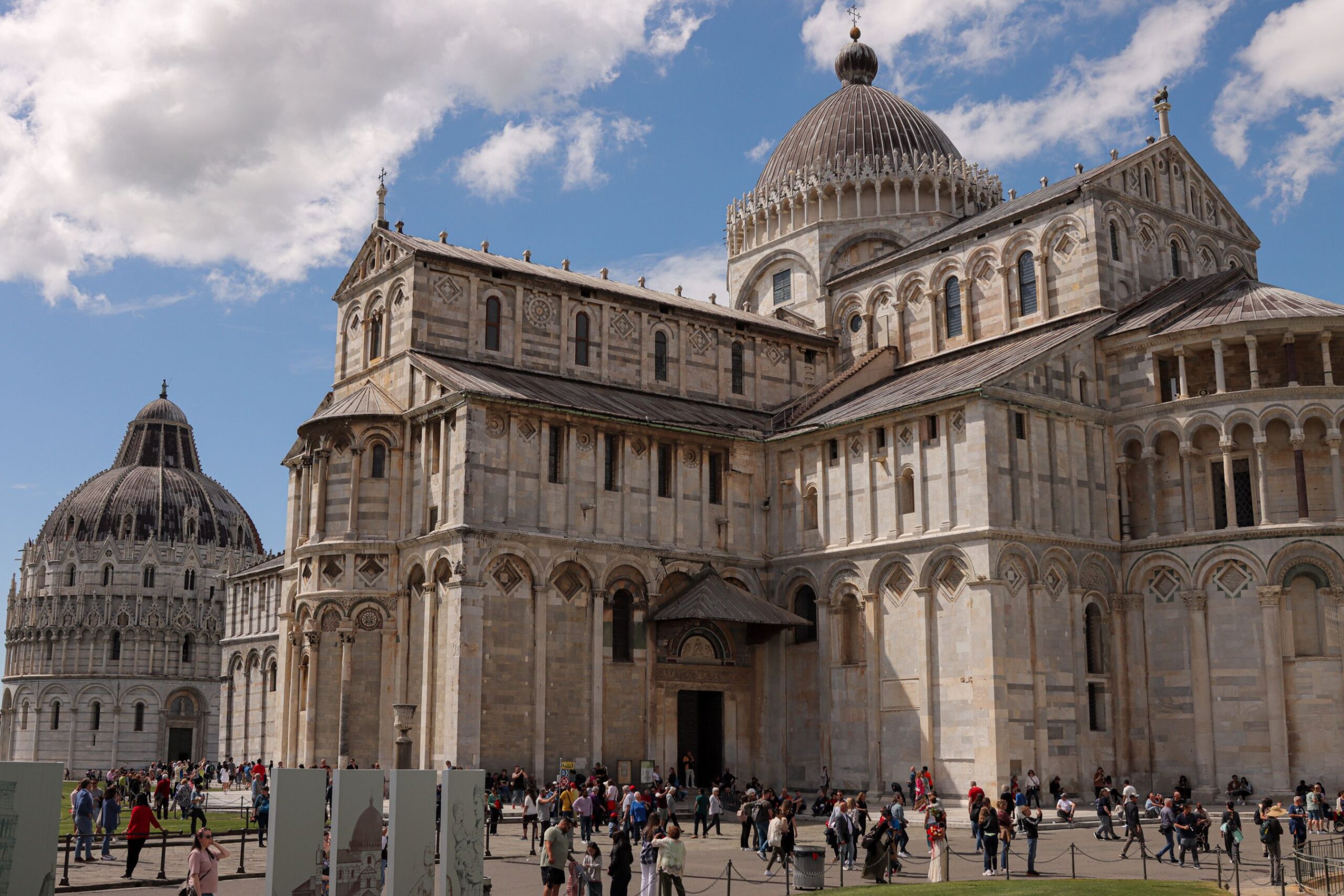 Turistas visitando la catedral y el baptisterio de Pisa