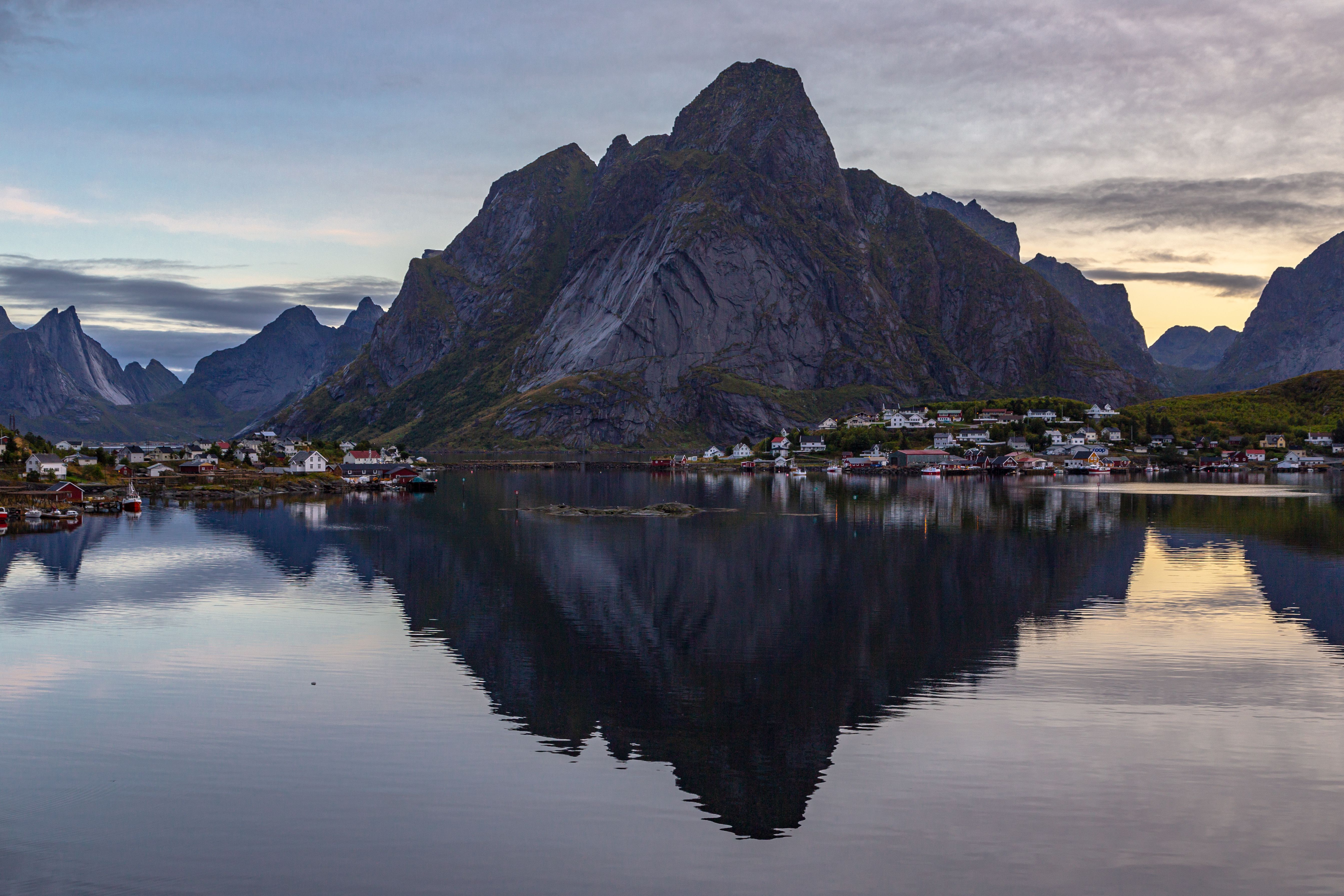 Reflejo del pueblo de Reine y las montañas en Lofoten al atardecer