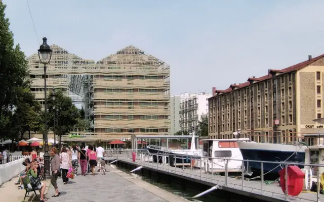 Canal y arquitectura moderna junto a un parque urbano en París