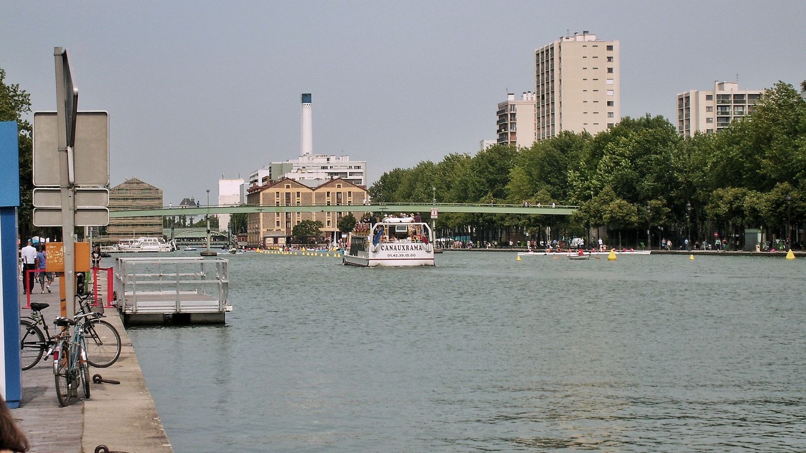 Canal con barcas junto a zonas verdes en un parque de París