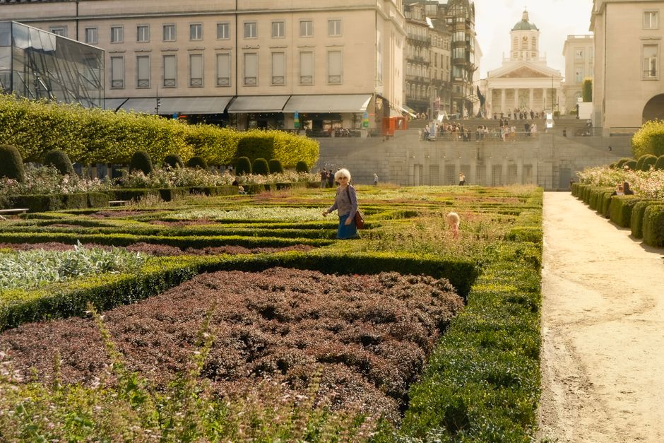 Jardines en Bruselas con un edificio historico al fondo