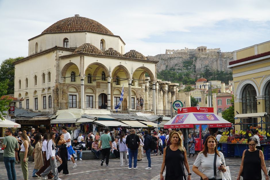 Mercado concurrido en Atenas con la Acropolis visible al fondo